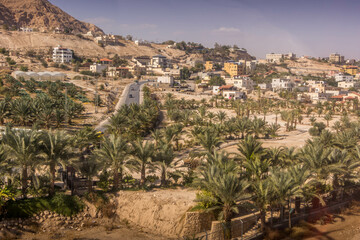 The aerial view on the road, palm tree plantation, and residential houses at Palestinian town of...