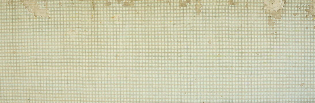 The texture of the old wall, decorated with a lot of square small tiles. Wall in the style of architecture of the Soviet Union