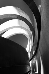 Striking monochrome architectural feature with sweeping curves and a dynamic interplay of light and...