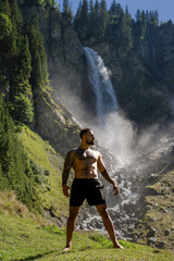 Man in Alps waterfall. Sexy man. Man freedom lifestyle. Meditating in nature. Hispanic man practicing yoga. Lifestyle relaxation concept, summer meditation on nature. Calmness and relax in nature.