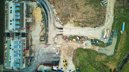 Aerial view of a construction site with building foundations and machinery.