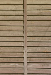 Vertical texture of a wall from several rows of brown old wooden boards. Painted wooden wall in brown color