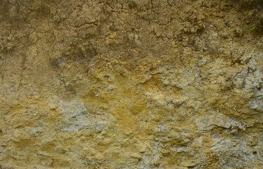 Texture of a wall of solid yellow and brown sand in a sandy quarry