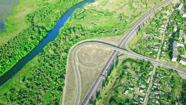 Aerial view of highway cross road junction at daytime. Cars are moving along the road junction. Urban infrastructure concept