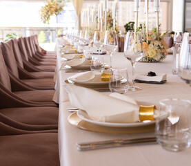 Serving the festive table at a wedding event. Decorating the wedding table with bouquets of flowers. Cutlery at a party 