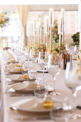Serving the festive table at a wedding event. Decorating the wedding table with bouquets of flowers. Cutlery at a party 
