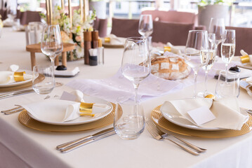 Serving the festive table at a wedding event. Decorating the wedding table with bouquets of flowers. Cutlery at a party 
