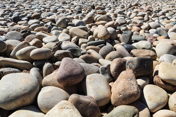 Abstract background of stones. Pebbles close-up, stone texture. Rounded stones close-up, slanted perspective view, soft focus