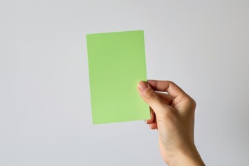 Hand hold color blank paper on white background.