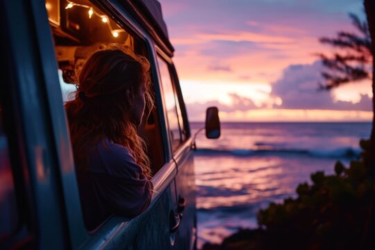 A young woman sitting inside van watching the sunset peacefully.