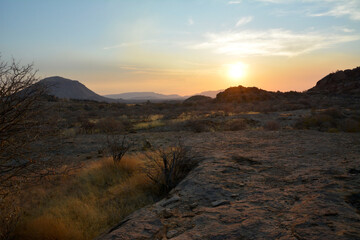 Sunset in the background among desert arid mountains. Natural landscape reserve. The wild nature