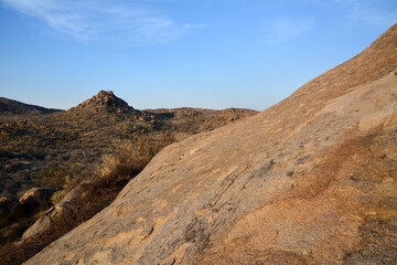 Slopes of a rocky mountain in the desert with sparse shrubs. Natural landscape reserve. Landscape wild nature