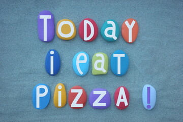 Today I eat pizza, creative slogan composed with hand painted multi colored stone letters over green sand