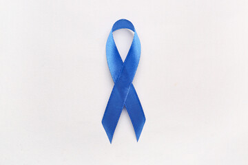 Blue awareness ribbon on light background. Prostate cancer concept