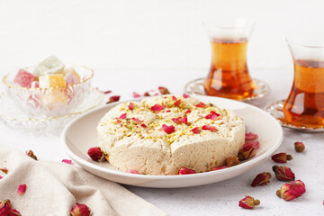 Plate of tasty Tahini halva with pistachios on light background