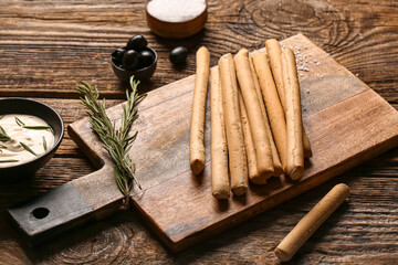 Board with tasty Italian Grissini on wooden background