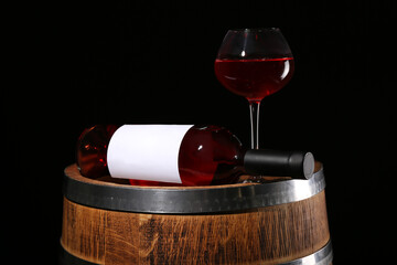 Wooden barrel with bottle and glass of wine on dark background