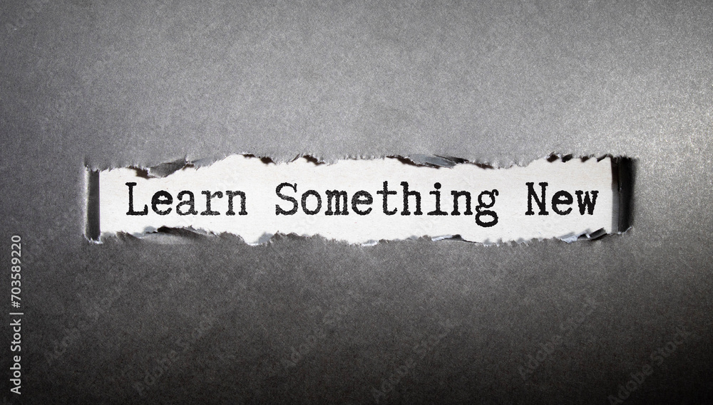 Poster text learn something new on black torn paper