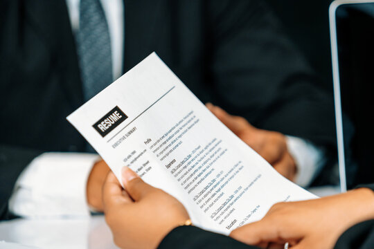 Human resources department manager reads CV resume document of an employee candidate at interview room. Job application, recruit and labor hiring concept. uds