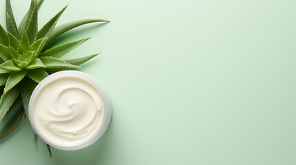 Obraz na płótnie Canvas Jar of cream with aloe vera on green background, top view