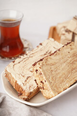 Bowl with pieces of tasty marble halva on light background
