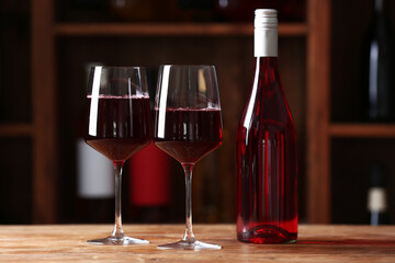 Bottle and glasses of red wine on table in cellar