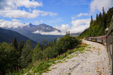 Fototapeta premium Narrow-gauge train of the White Pass and Yukon Route in the Alaskan mountains between Skagway and Canada