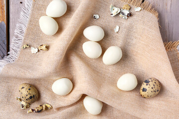 Boiled quail eggs with shells on grey wooden background