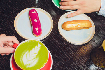 Glazed Cherry eclair on white dish topped with chocolate scribble candy served with a side of...