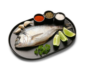 Tray of raw dorado fish with lime and spices on white background