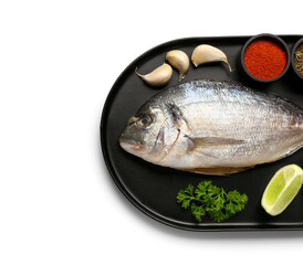 Tray of raw dorado fish with lime and spices on white background
