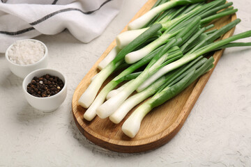 Board with fresh green onion and peppercorn on white background