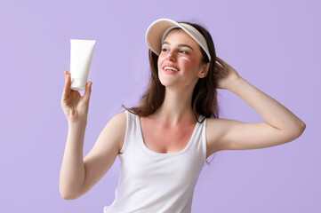 Allergic young woman with sunburned face and cream on lilac background