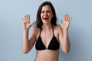 Allergic young woman with sunburned skin on blue background