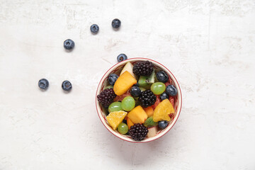 Bowl of fresh fruit salad on light background