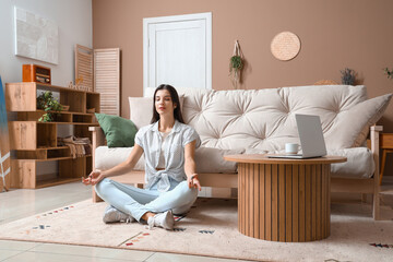 Young woman meditating on carpet in living room
