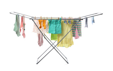 Clean baby clothes hanging on dryer against white background