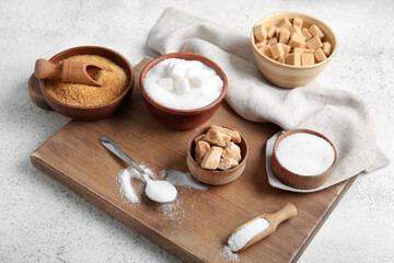Bowls different types of sugar on white background