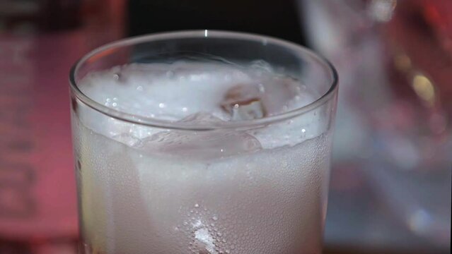 Bebida espumosa en un vaso con hielos