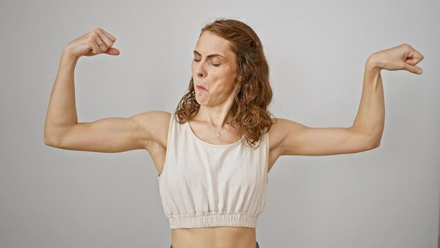 Powerful young woman flexes arm muscles, beaming with confidence on white isolated background - inspiring fitness success story!