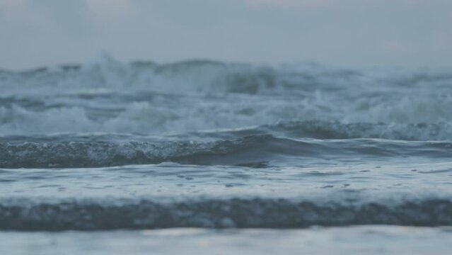 Waves crashing on Formby beach seen through telephoto lens