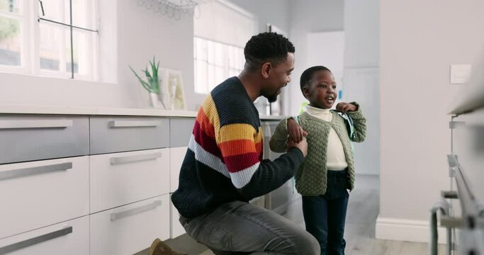 Education, backpack and a father with his son getting ready for school in the kitchen of their home together. Family, children and a man hugging his kid for goodbye in the house before leaving