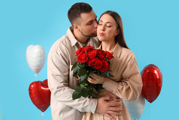 Lovely couple with bouquet of roses and heart-shaped balloons on blue background. Valentine's Day...