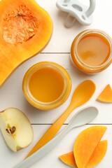 Tasty baby food in jars, pacifier and ingredients on white wooden table, flat lay