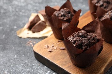 Tasty chocolate muffins on grey table, closeup. Space for text