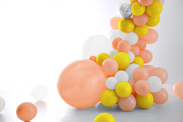 Balloon garland near white wall in room. Festive decor