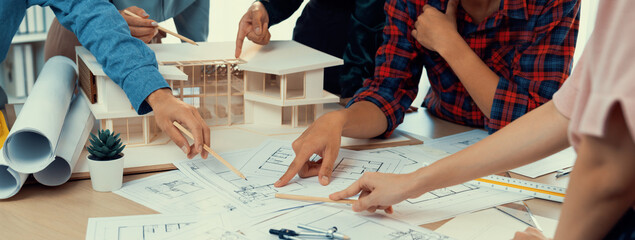 Skilled architect engineer team meeting pointing at blueprint while professional interior designer analysis and brainstorming about house structure. Creative design and teamwork concept. Burgeoning. - obrazy, fototapety, plakaty