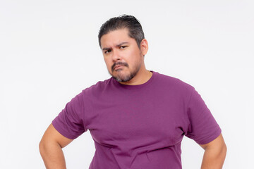 Obraz premium A wary middle aged man looks at someone with suspicioun. Wearing a purple waffle shirt, Isolated on a white background.