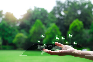 Eco friendly and save the world concept. Hand with World map and green leaf icon in a garden with...