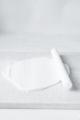 Rolled out white fondant on a marble countertop, fondant being prepared for use